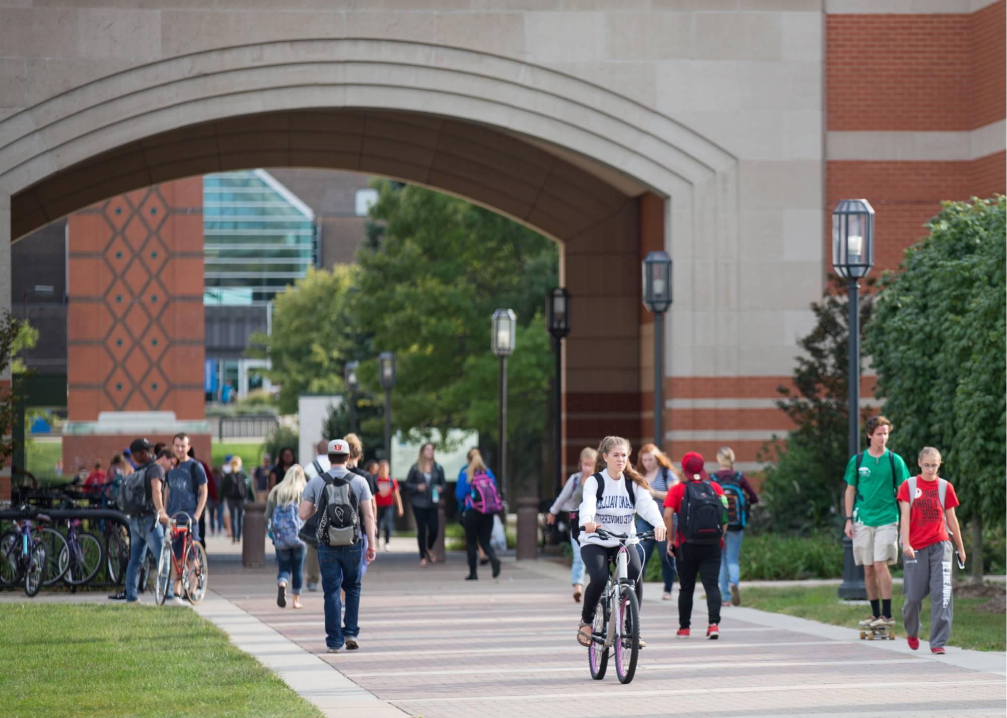 Candid of students walking under Henry Hall Arch